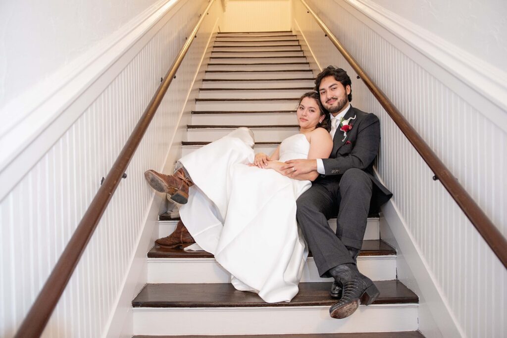 Bride and groom posing on the historic staircase inside Historic Heights Firehouse in Houston, Texas